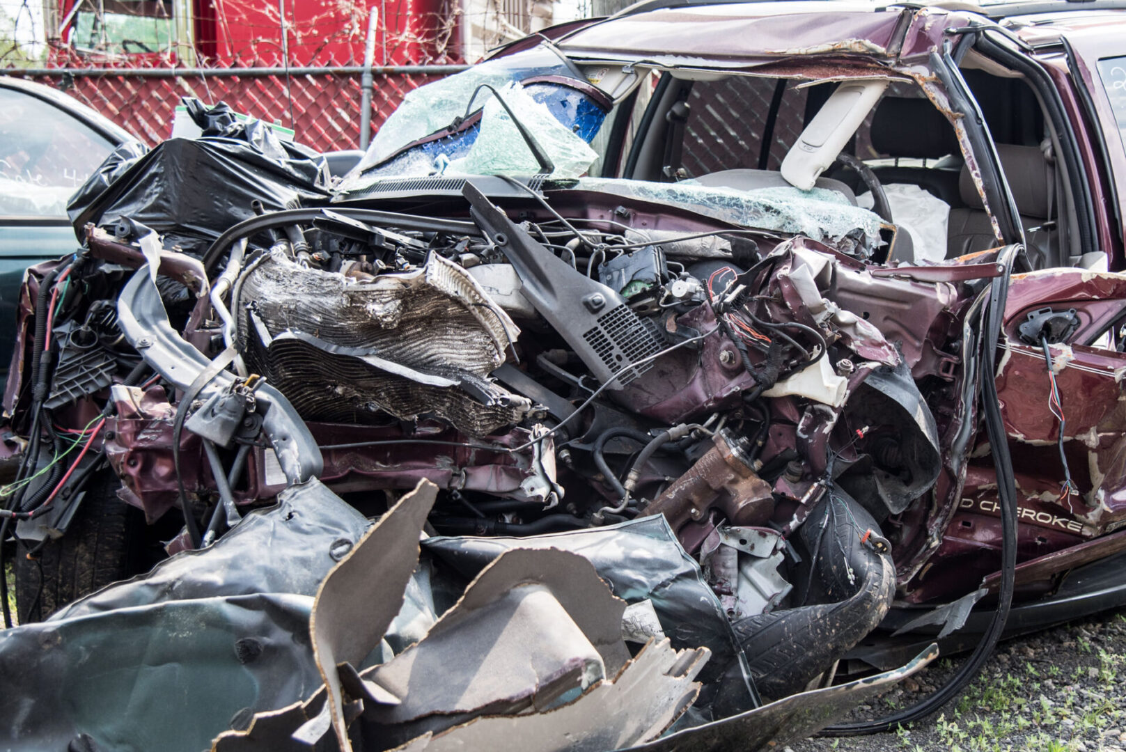 Heavily wrecked maroon SUV with crushed front
